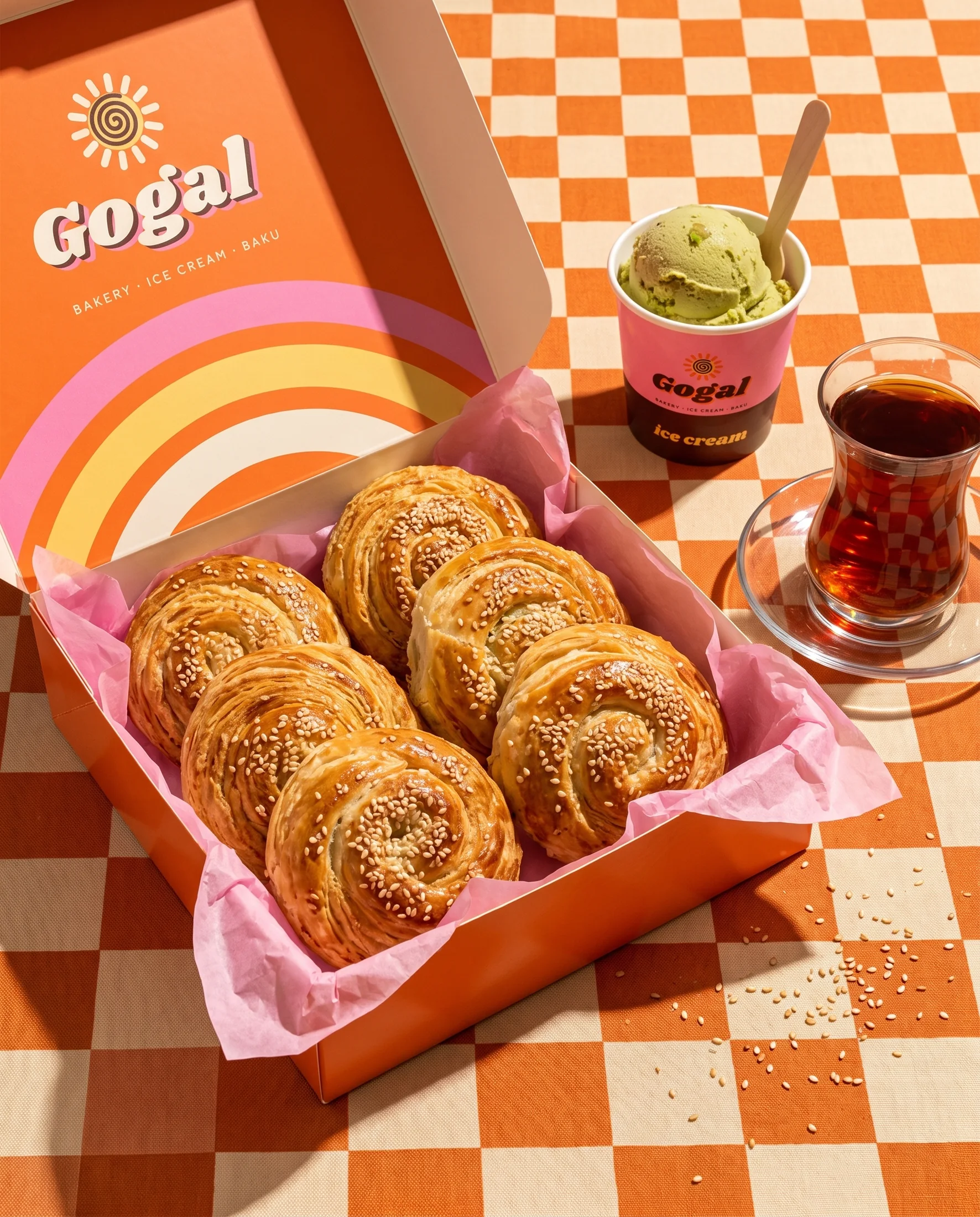 An open box of six gogal with an ice cream cup and tea