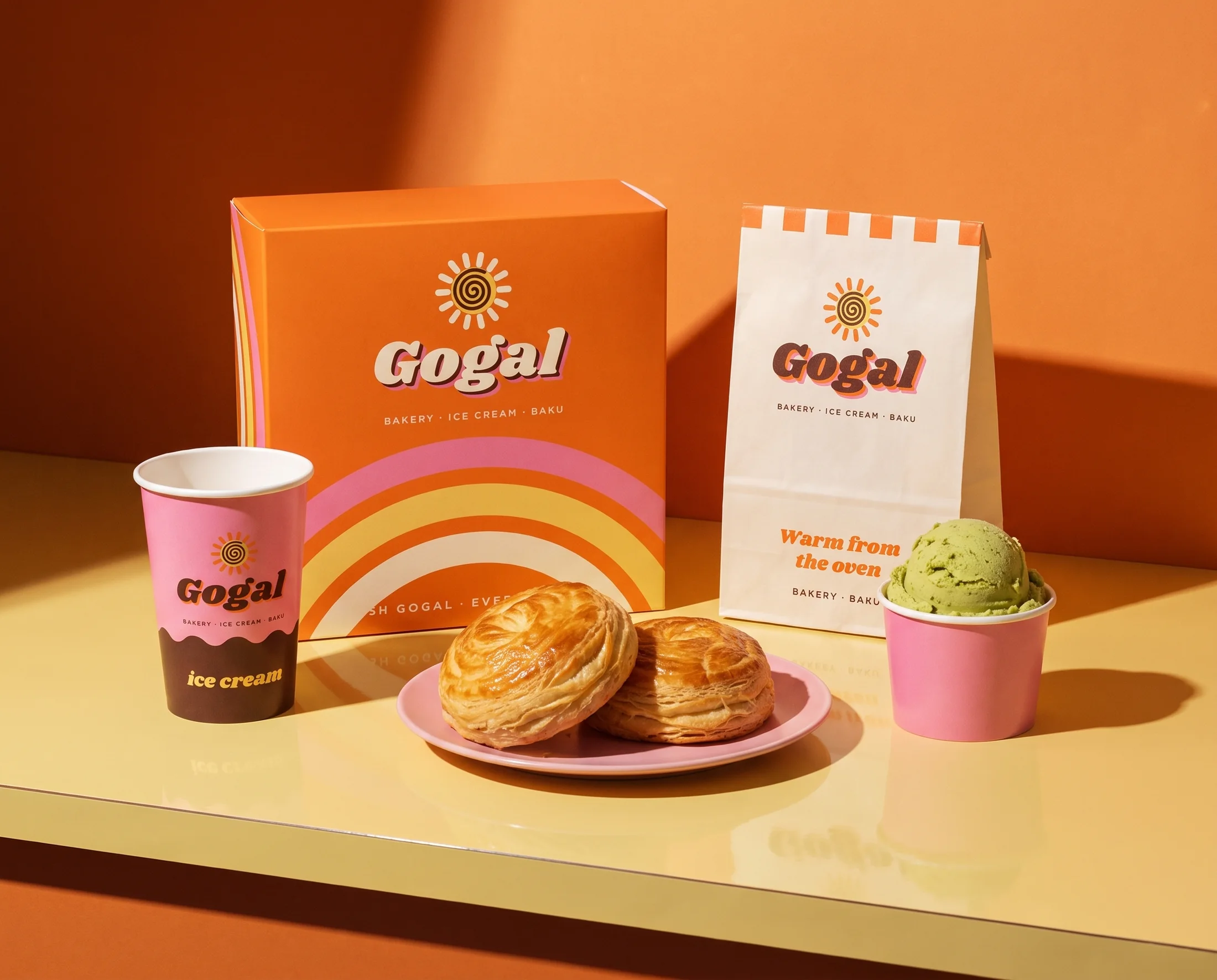 Gogal pastry box, ice cream cups and paper bag on a yellow counter