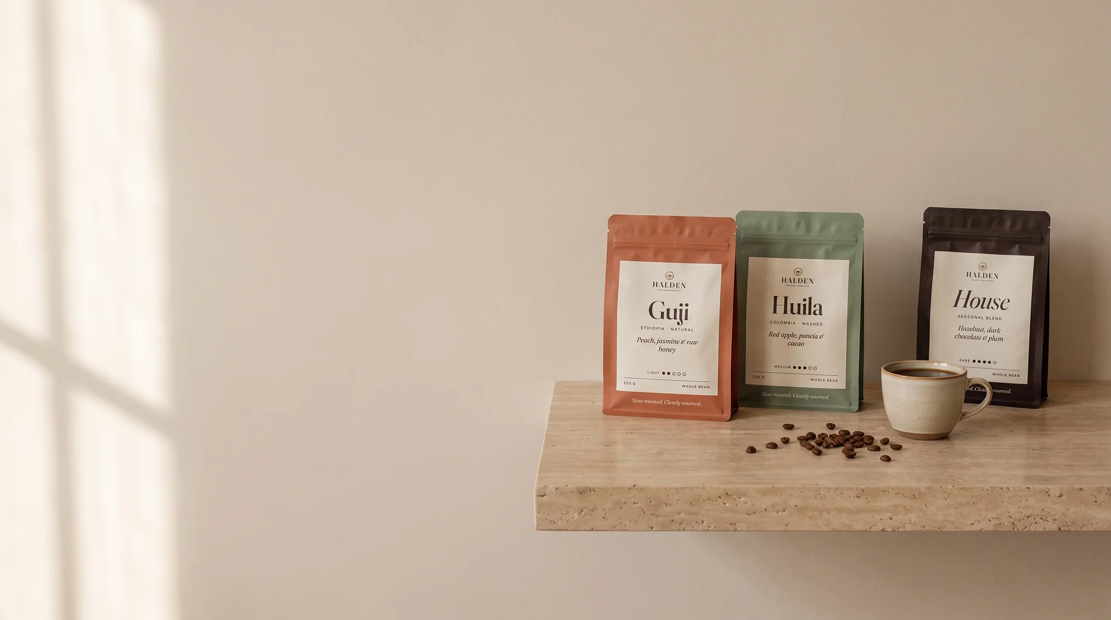 Three Halden coffee bags on a travertine shelf